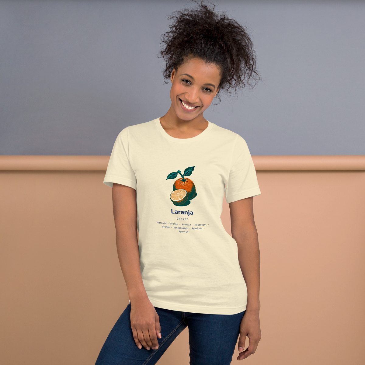 A woman wearing the Laranja shirt, Portuguese run, against a warm wall.